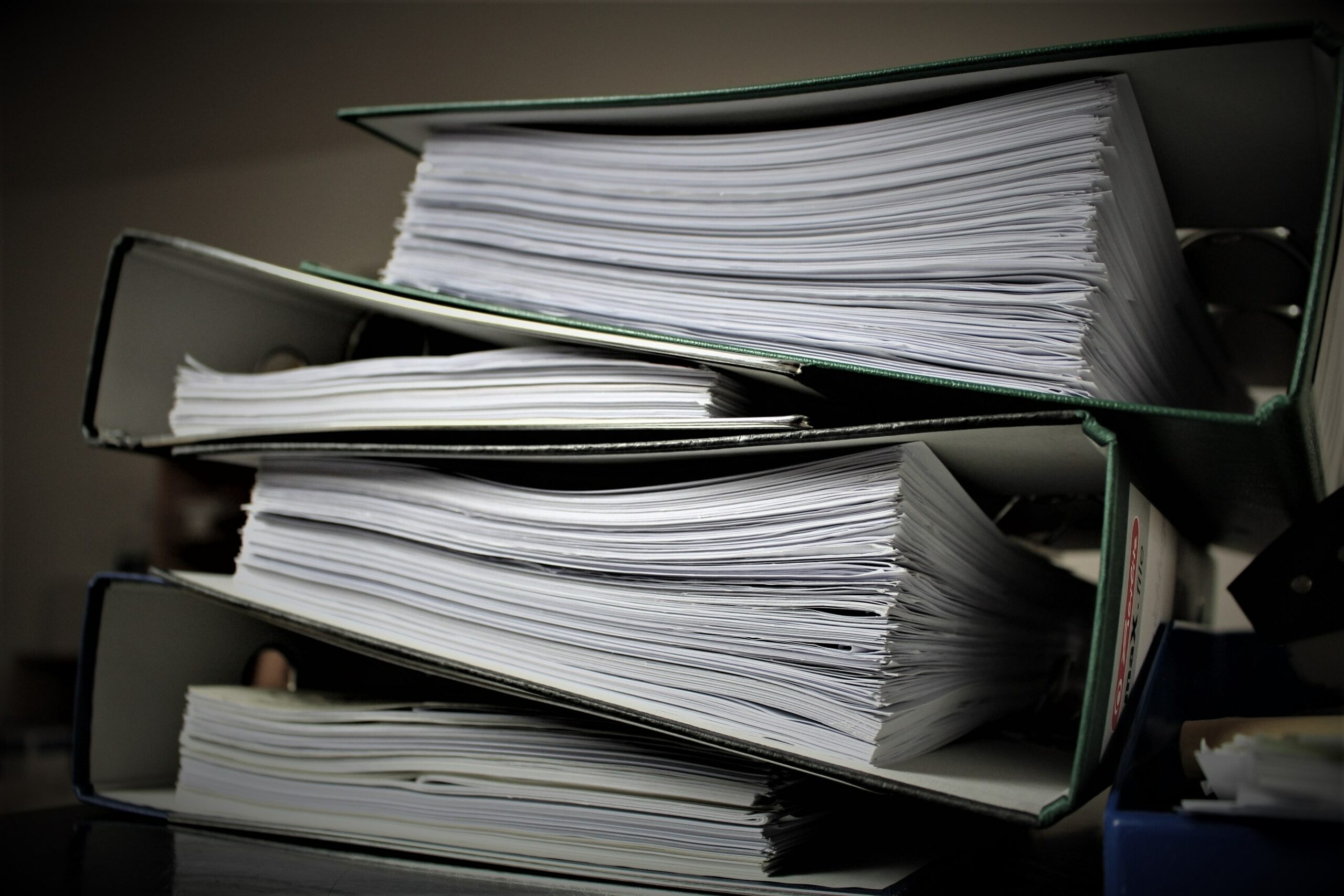 A stack of binders full of documents