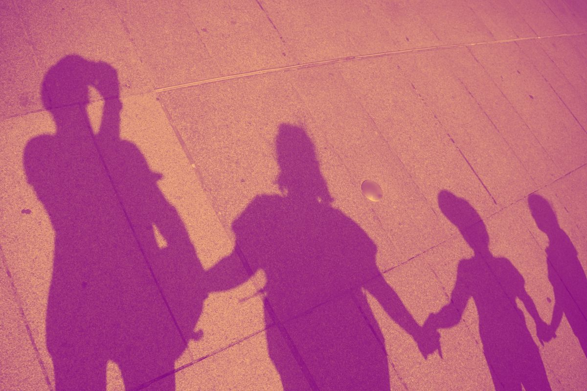The shadows of a family cast on a sidewalk