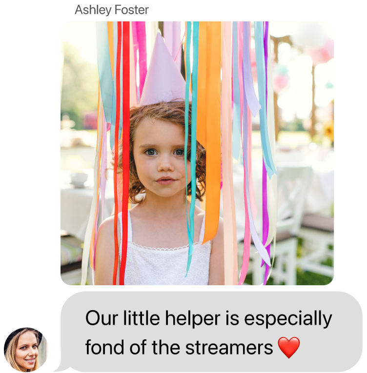 Ashley Foster sends a photo of a girl wearing a party hat standing among colorful streamers, then: Our little helper is especially fond of the streamers ❤️